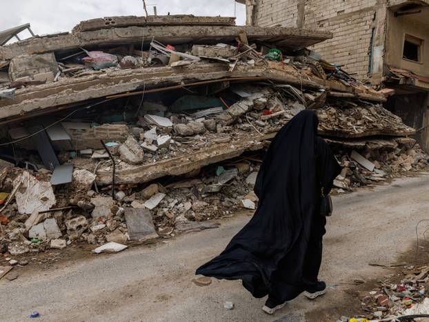 People cross a damaged bridge in Zrarieh