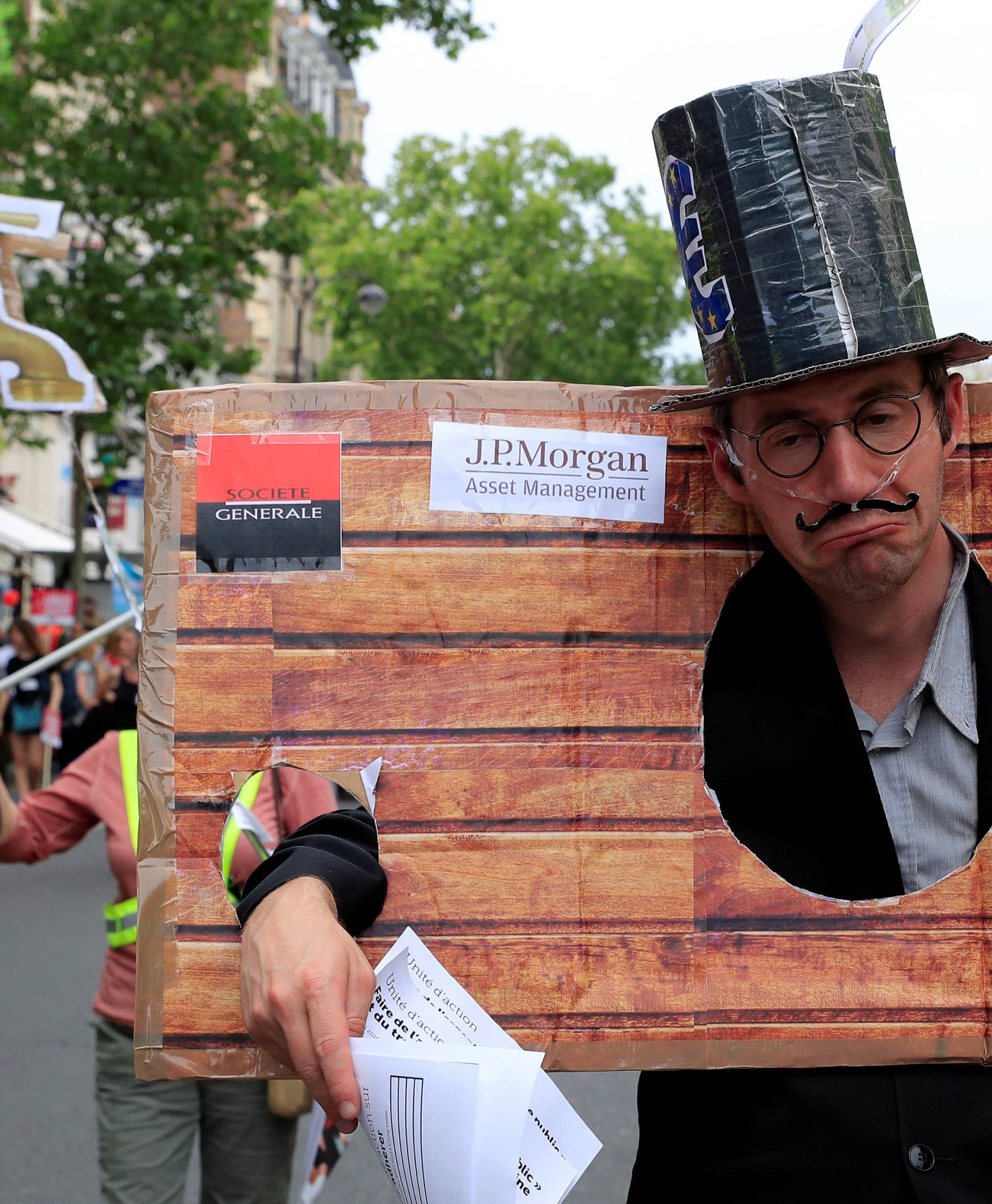 A protester dressed as a banker attends a demonstration by French unions and France Insoumise" (France Unbowed) political party to protest against government reforms, in Paris