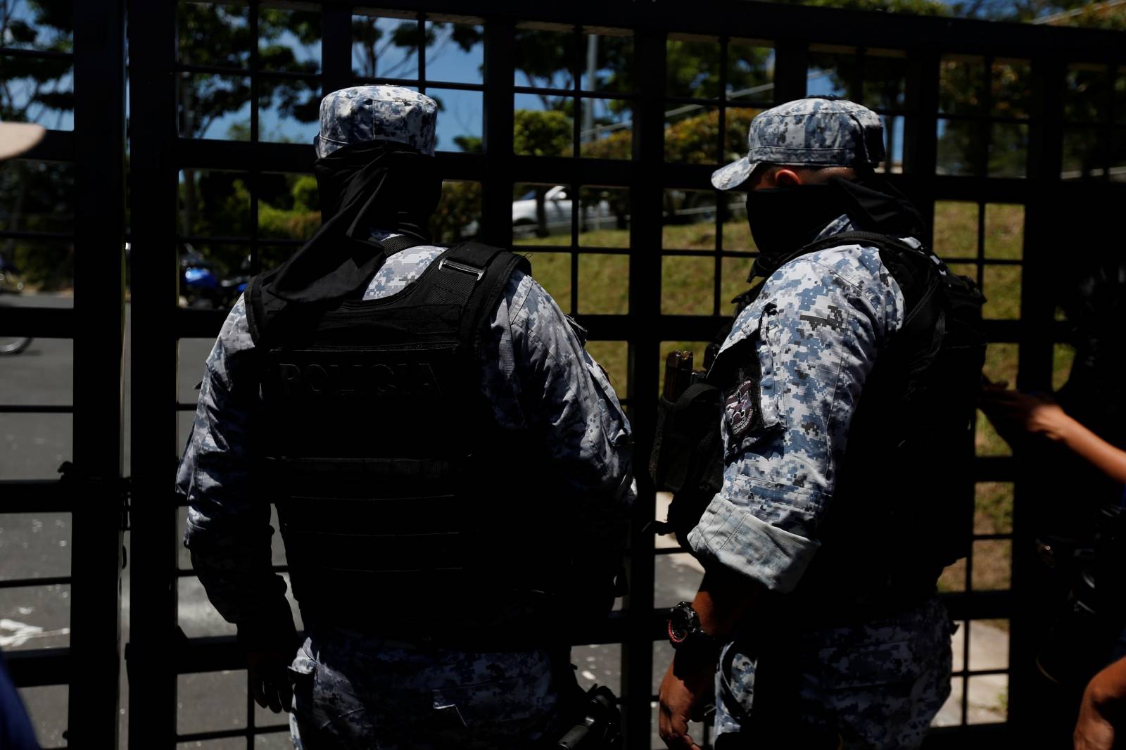 Police officers stand outside where the remains of Oscar Alberto Martinez Ramirez and his daughter Valeria, migrants who drowned in the Rio Grande river during their journey to the U.S., arrive, at La Bermeja cemetery in San Salvador