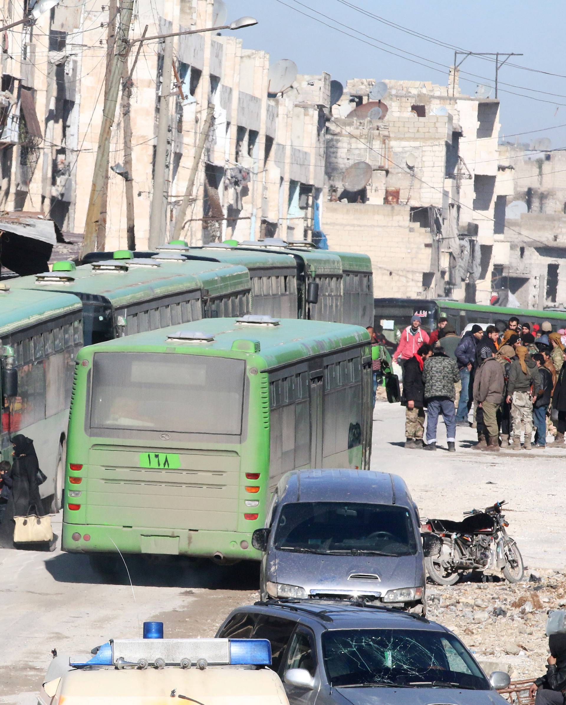 People get on buses to be evacuated from al-Sukkari rebel-held sector of eastern Aleppo