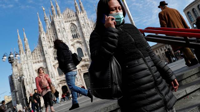 A woman wearing a protective face mask to prevent contracting the coronavirus enters a subway station in Milan