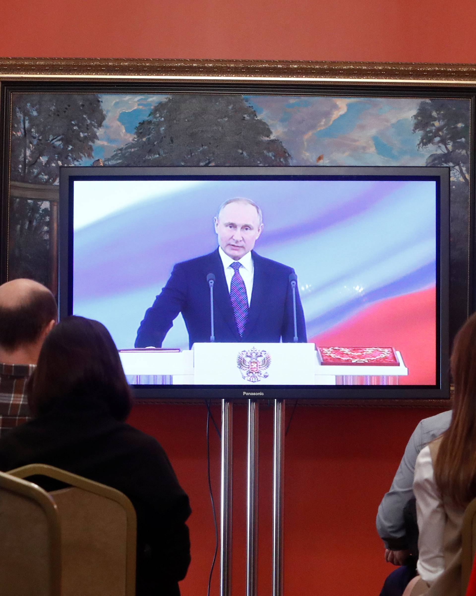 Journalists watch a ceremony to inaugurate Vladimir Putin as President of Russia at a press centre in Moscow