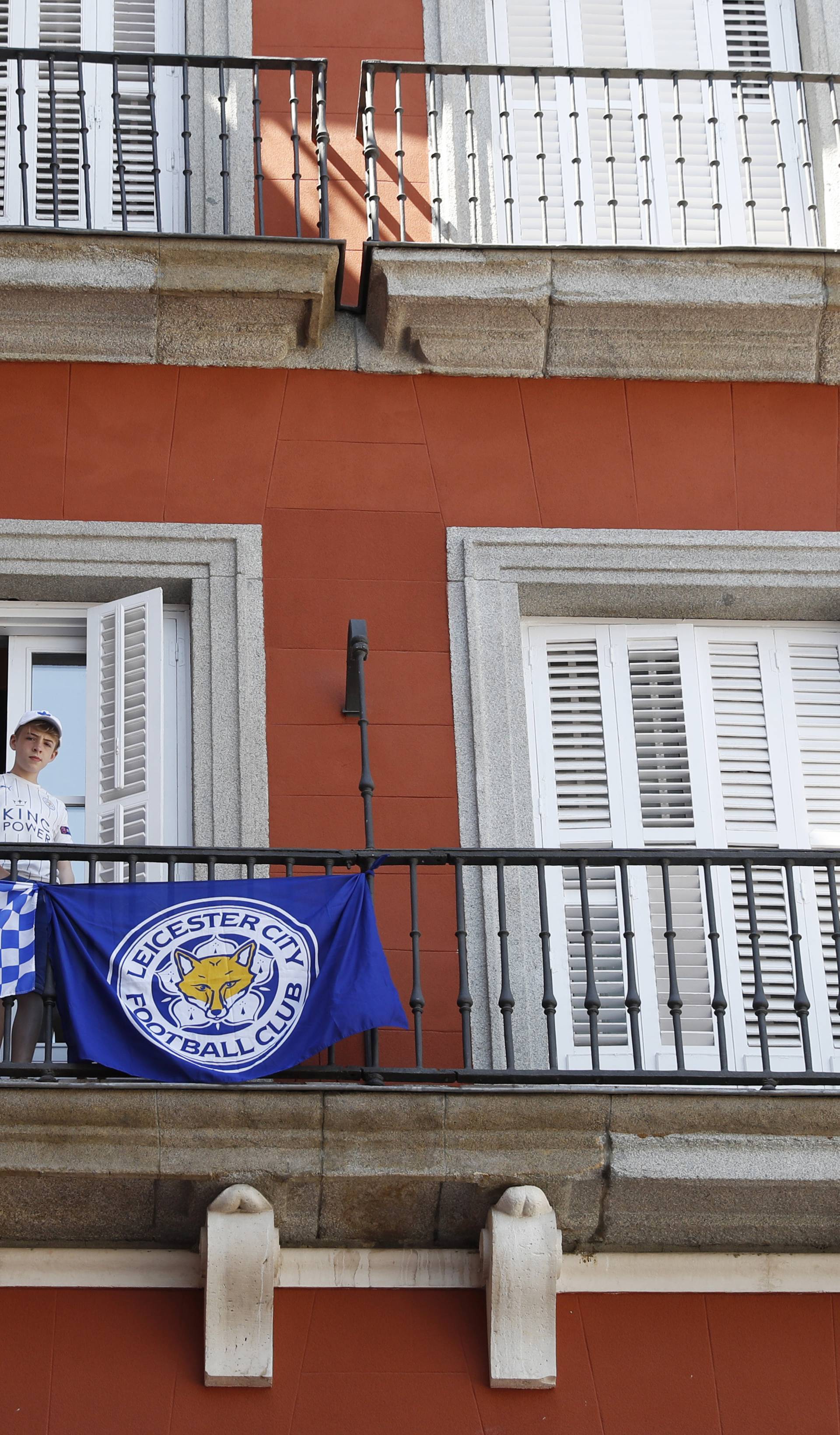 A Leicester City fan with flags displayed over a balcony in the Plaza Mayor before the match