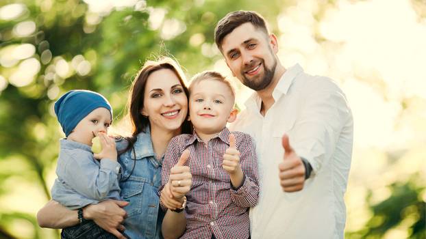 POSITIVE AND STYLISH FAMILY Gesturing Super by Fingers at Camera.