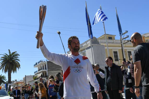 US actor Gerard Butler takes part in the Olympic flame torch relay for the Tokyo 2020 Summer Olympics