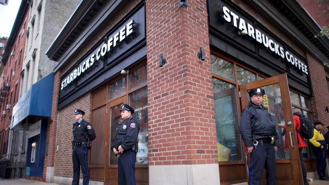 Police officers monitor activity outside as protestors demonstrate inside a Center City Starbucks, where two black men were arrested, in Philadelphia