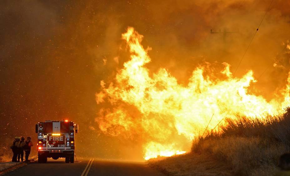 Handout photo of a fire crew taking shelter behind an engine as the Sherpa Fire advances at El Capitan State Beach in Santa Barbara