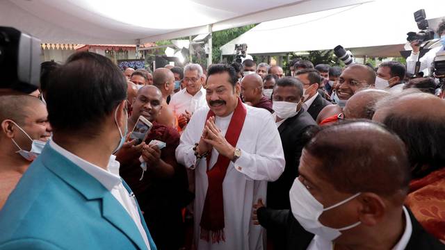 FILE PHOTO: Sri Lanka's Prime Minister Mahinda Rajapaksa gestures as he leaves after his swearing in ceremony  as the new Prime Minister, at Kelaniya Buddhist temple in Colombo