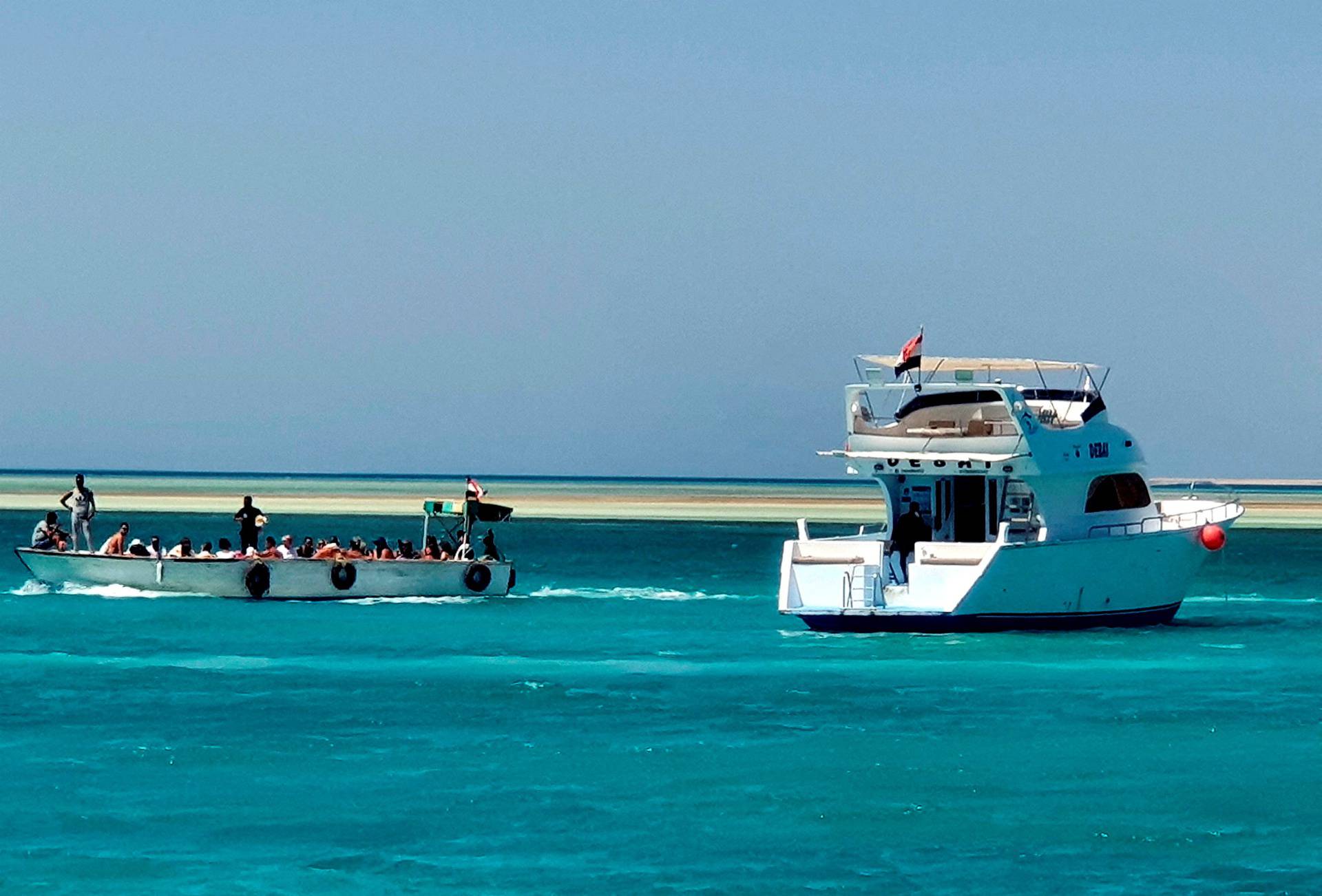 Tourists take a tour next to a docked yacht in the marina at the Egyptian Red Sea resort of Hurghada after a tourist boat sank off Red Sea coast