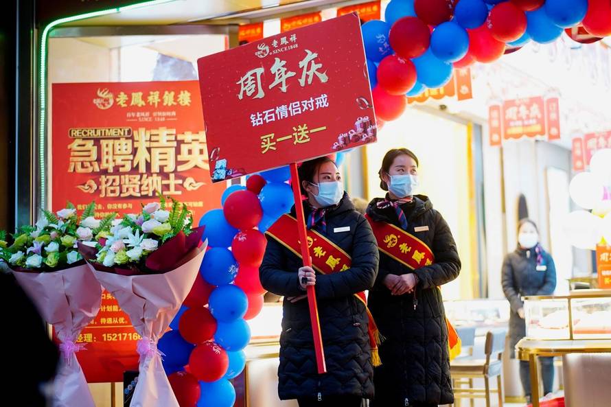 Sales assistants of a jewellery store wear face masks while doing promotions at a main shopping area almost a year after the global outbreak of the coronavirus disease (COVID-19) in Wuhan