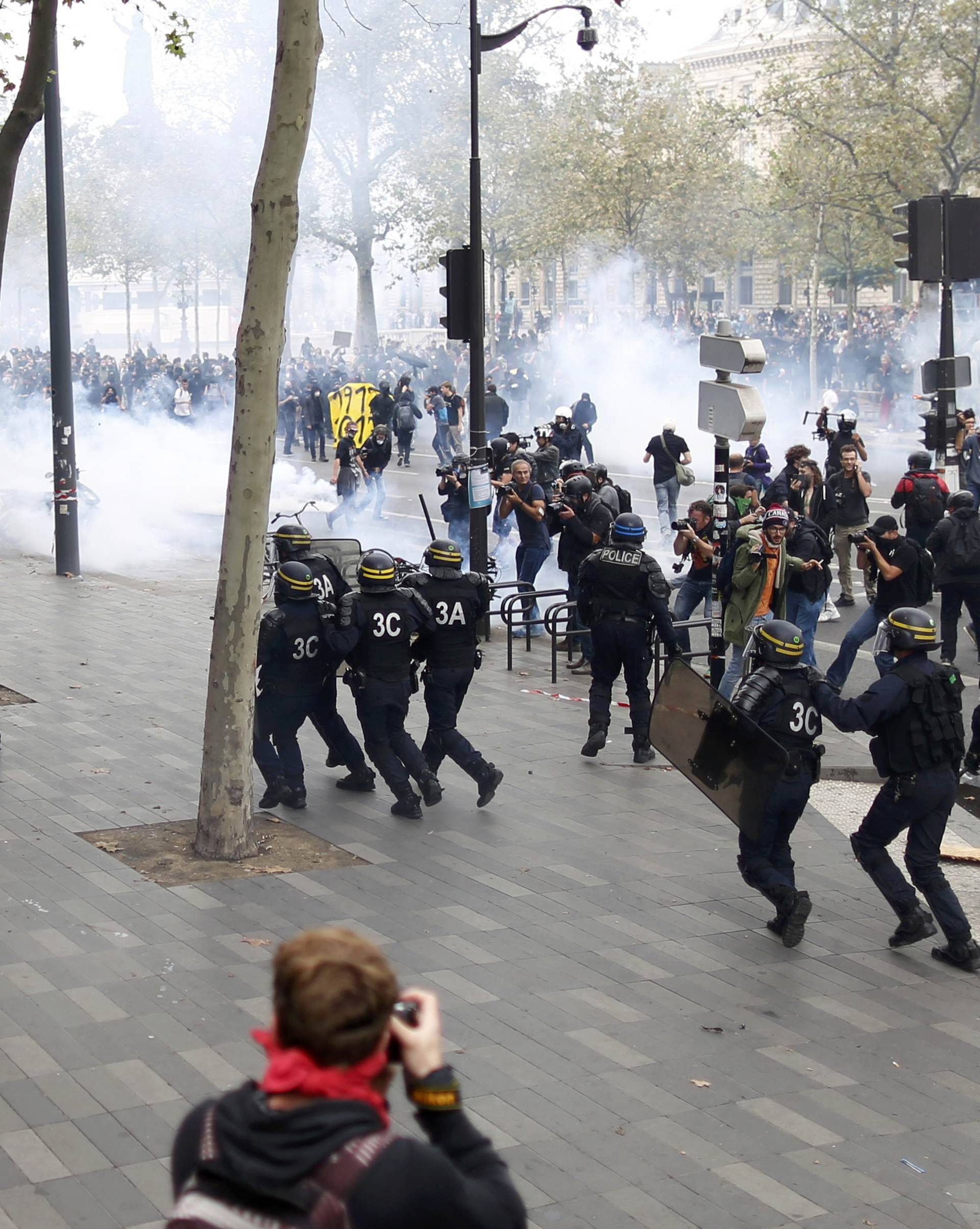 Demonstrators clash with French riot police during a march in Paris