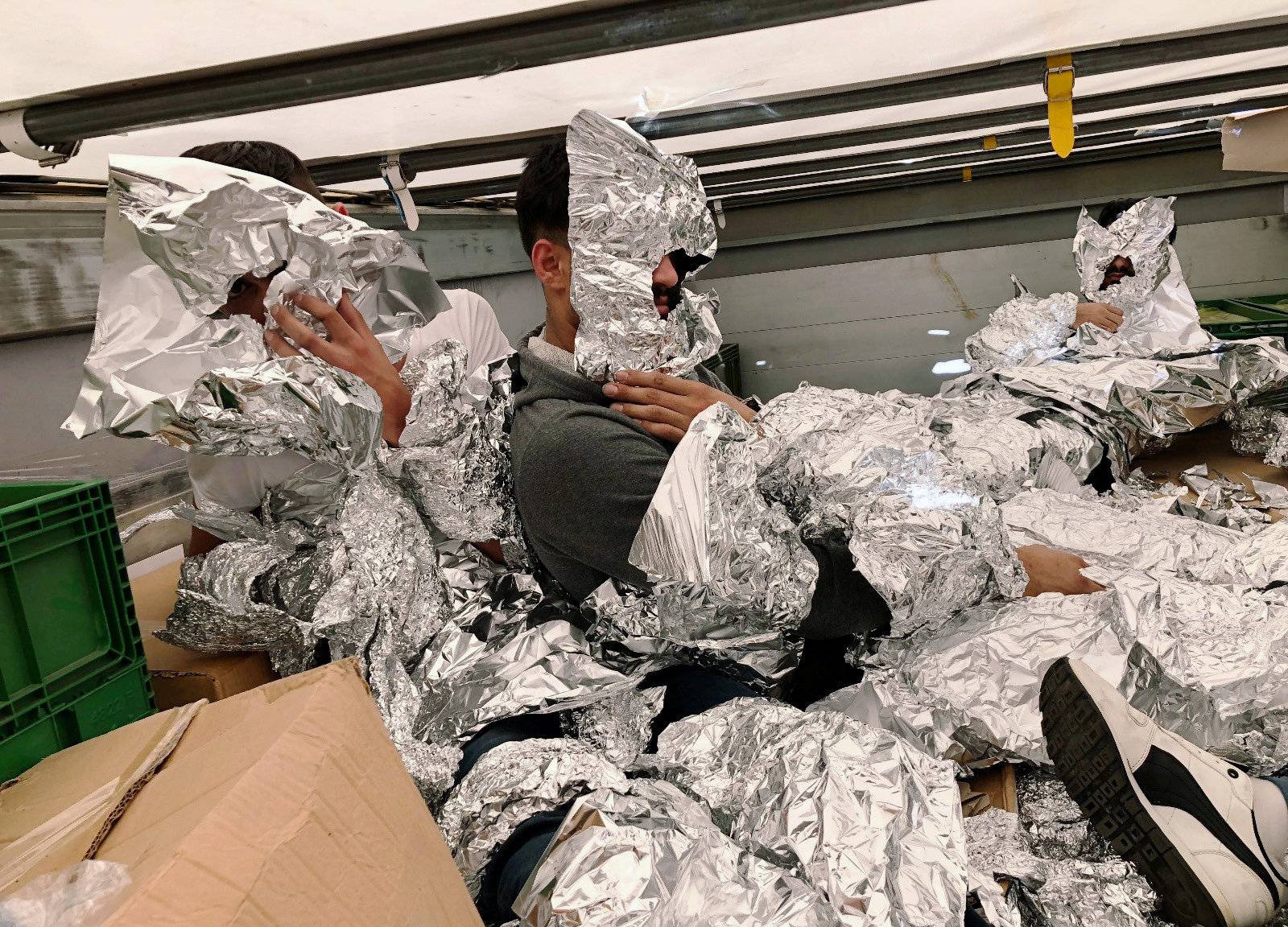 3 of the 7 Iraqi refugees wrapped in aluminium foil to hide from an x-ray detector are pictured inside a truck at Pendik Port as they try to reach Italy in Istanbul