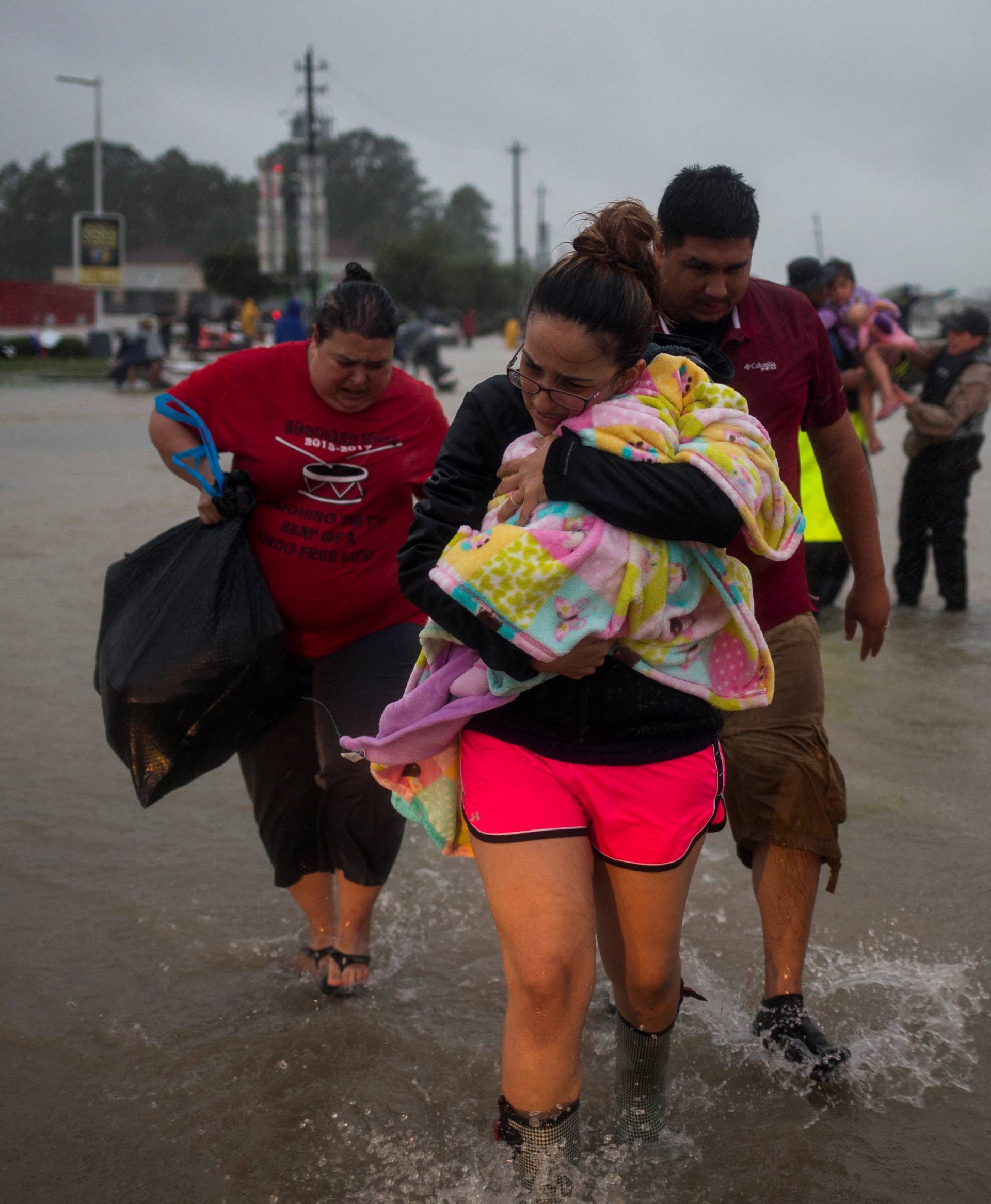 A family arrives to high ground after they fled their home due to floods caused by Tropical Storm Harvey along Tidwell Road in east Houston