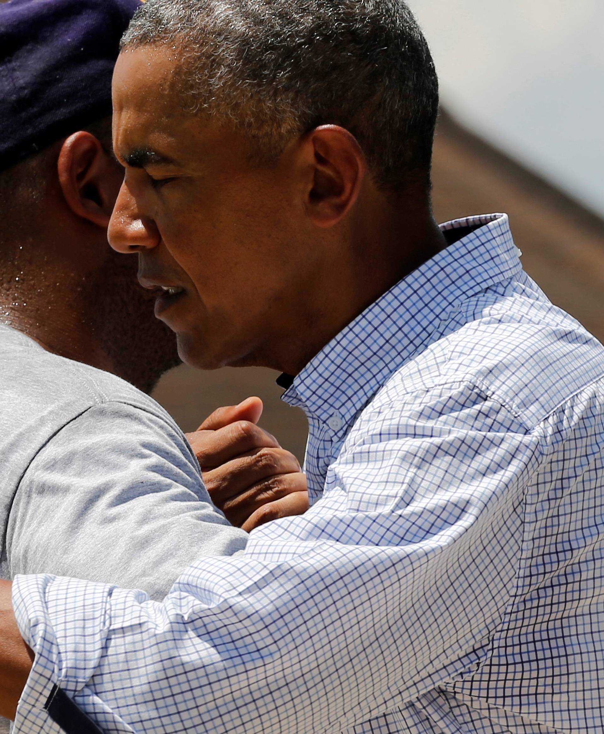 U.S. President Barack Obama greets a resident as he tours a flood-affected neighborhood in Zachary