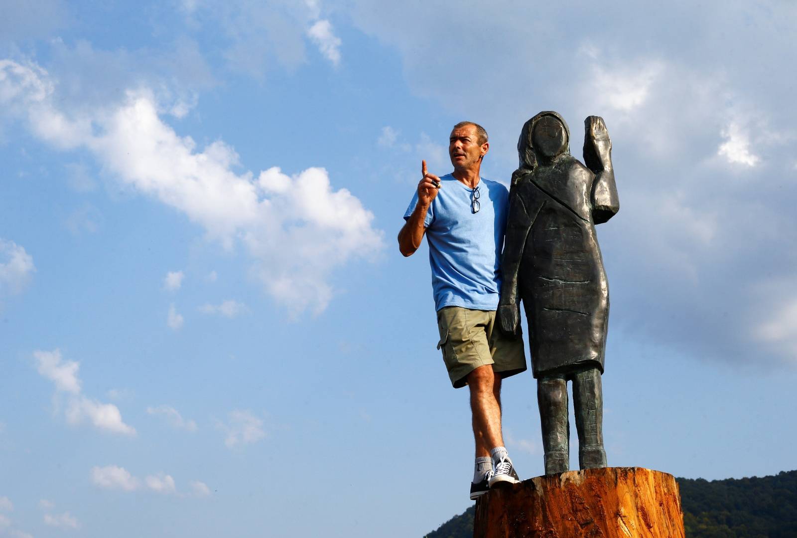 Ales Zupevc poses next to the new bronze statue of U.S. first lady Melania Trump in Rozno, near her hometown of Sevnica