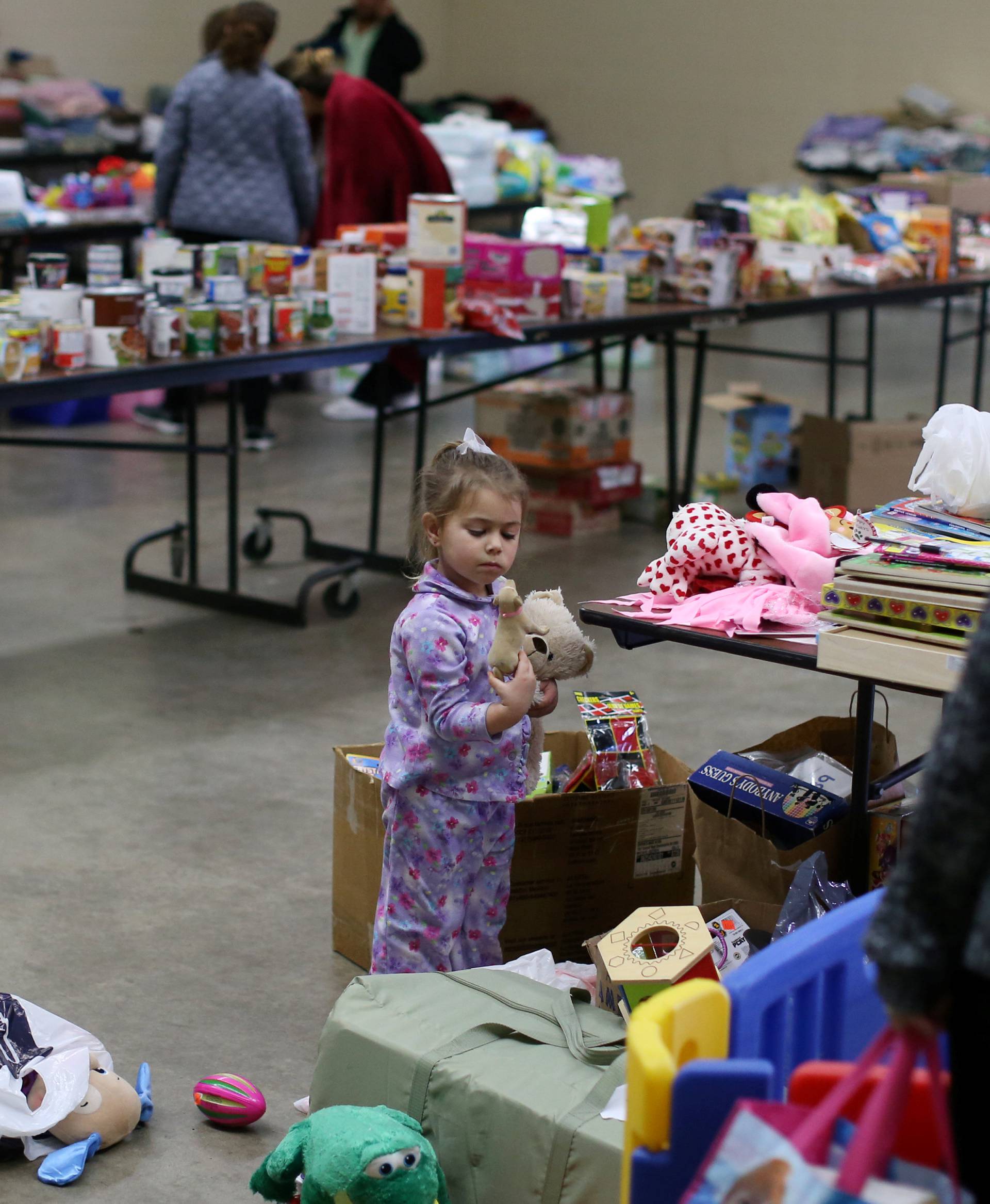 Emma Neurohr, 4, of Oroville, looks through toys from the Salvation Army relief center at the Placer County Fairgrounds in Roseville, California, after an evacuation was ordered for communities downstream from the dam in Oroville
