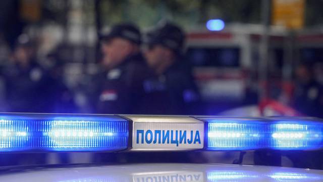 Police officers secure the area after a 14-year-old boy opened fire on other students and security guards at a school in downtown Belgrade