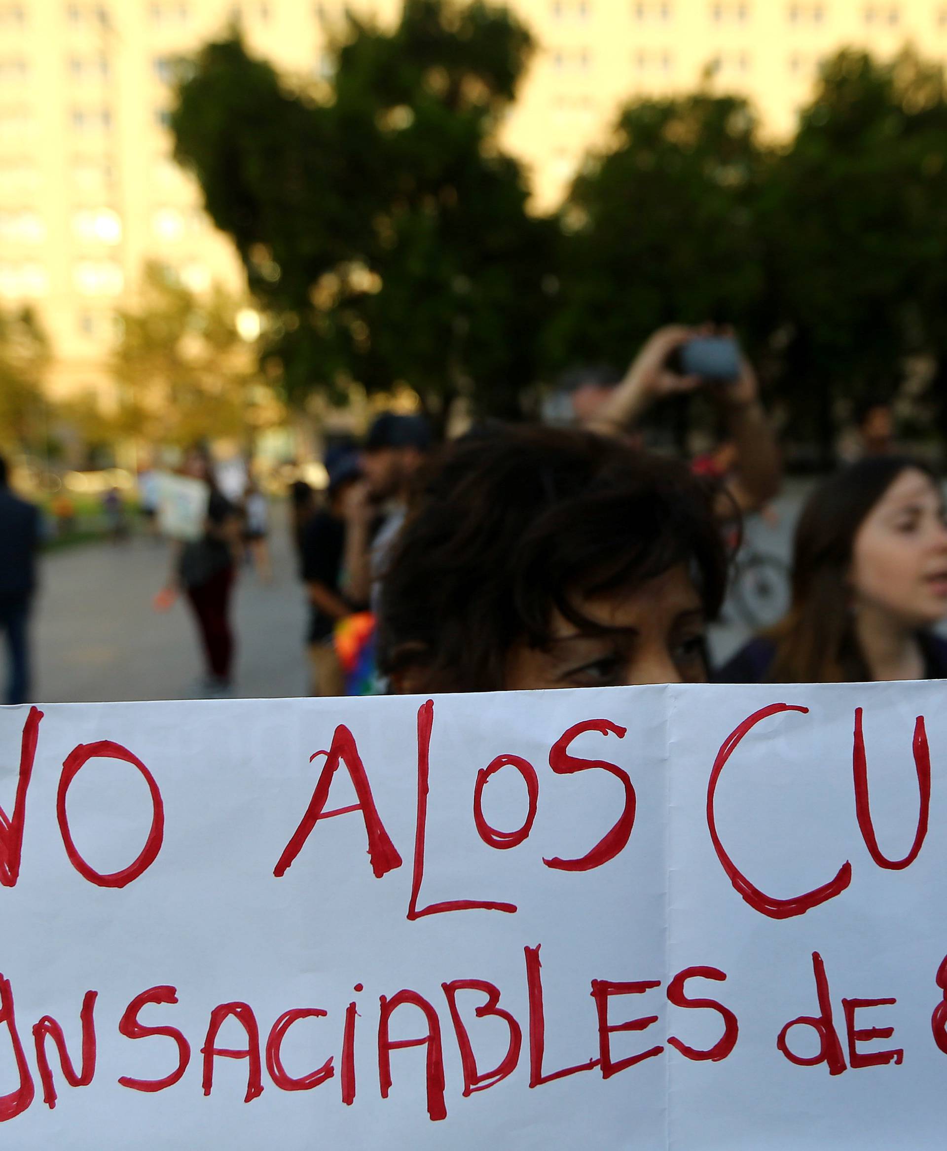 A woman holds a banner reading "Not to the insatiable crows of the U.S." during a rally against the Trans-Pacific Partnership (TPP) trade deal in Santiago