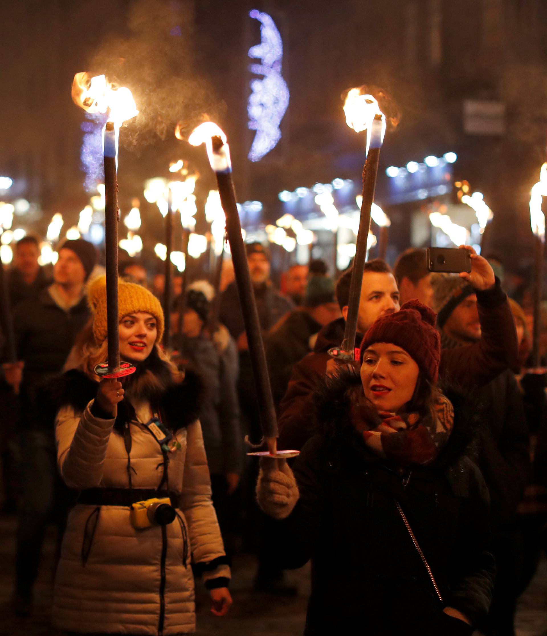 People attend the Edinburgh's Hogmanay torchlit procession down the Royal Mile in Edinburgh