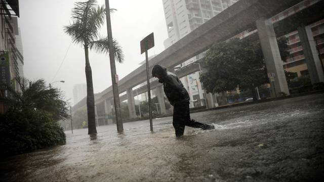 A local resident walks across a flooded street in downtown Miami as Hurricane Irma arrives at south Florida