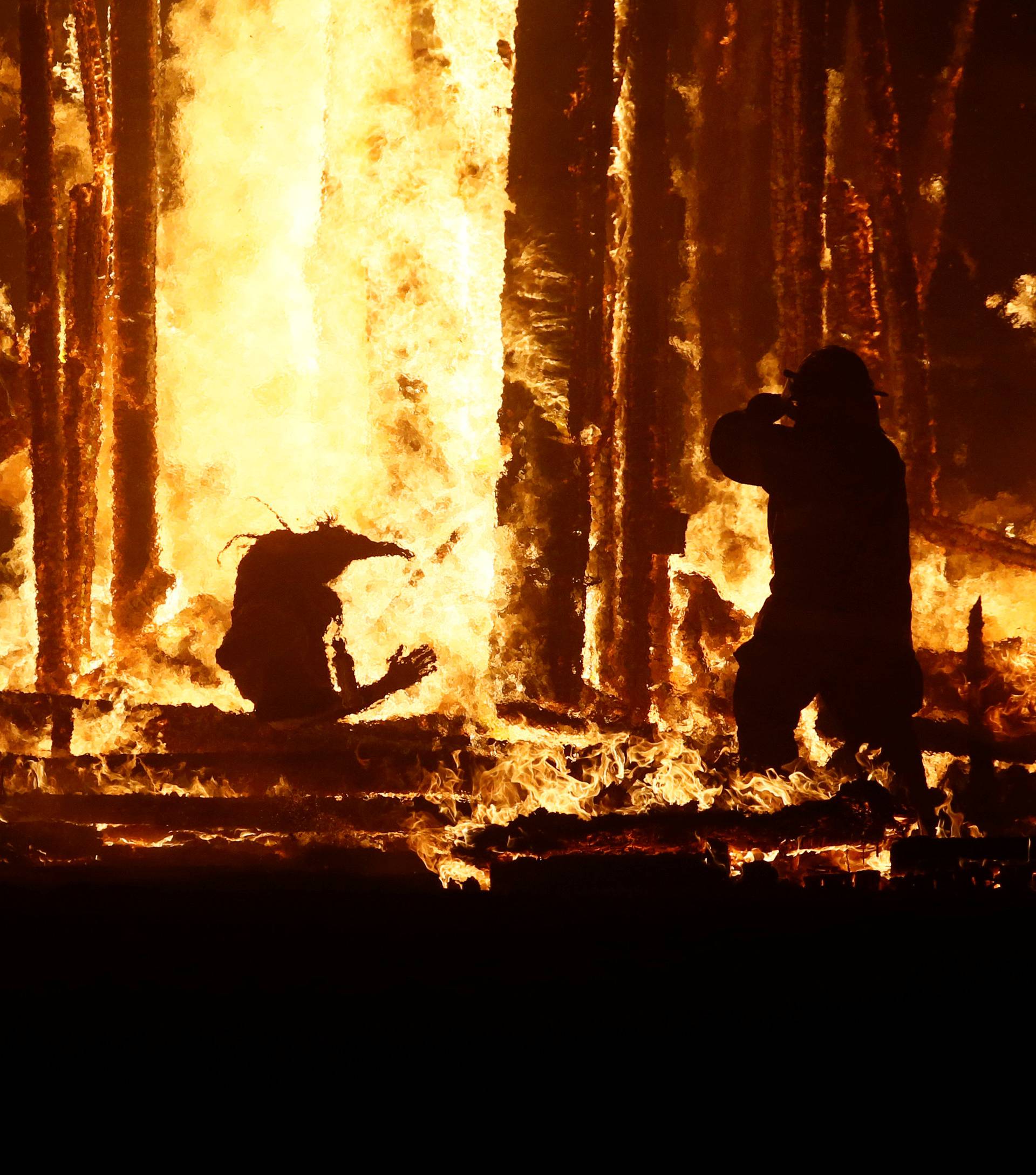 Burning Man participant runs into the flames of the "Man Burn" at the Burning Man arts and music festival in the Black Rock Desert of Nevada