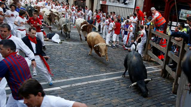 Runners sprint ahead of bulls during the first running of the bulls at the San Fermin festival in Pamplona
