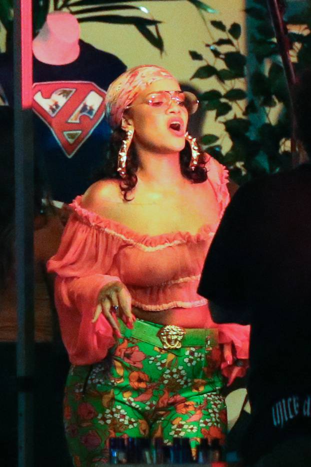 Rihanna rocks a pair of incredible skintight green print high-heeled pants as she films her new music video in the heart of Little Haiti in Miami, accompanied by DJ Khaled