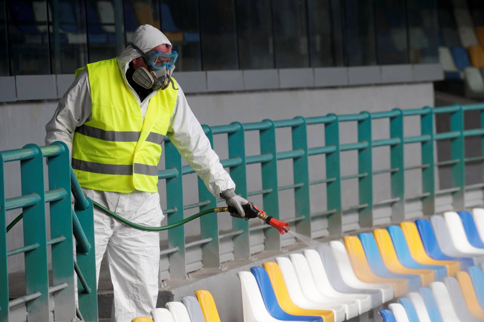 A cleaner wearing a protective suit sanitises seats at the San Paolo stadium ahead of the second leg of the Coppa Italia semi-final between Napoli and Inter Milan, which has since been postponed