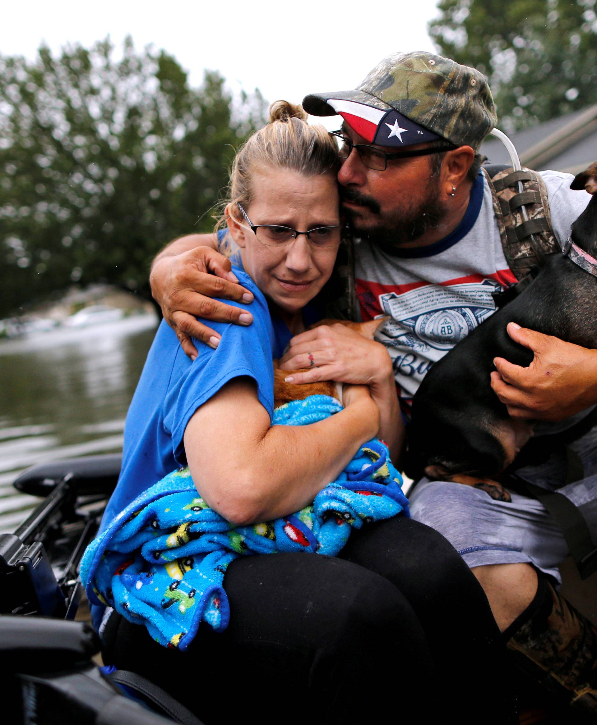 David Gonzalez comforts his wife Kathy after being rescued from their home flooded by Tropical Storm Harvey in Orange, Texas