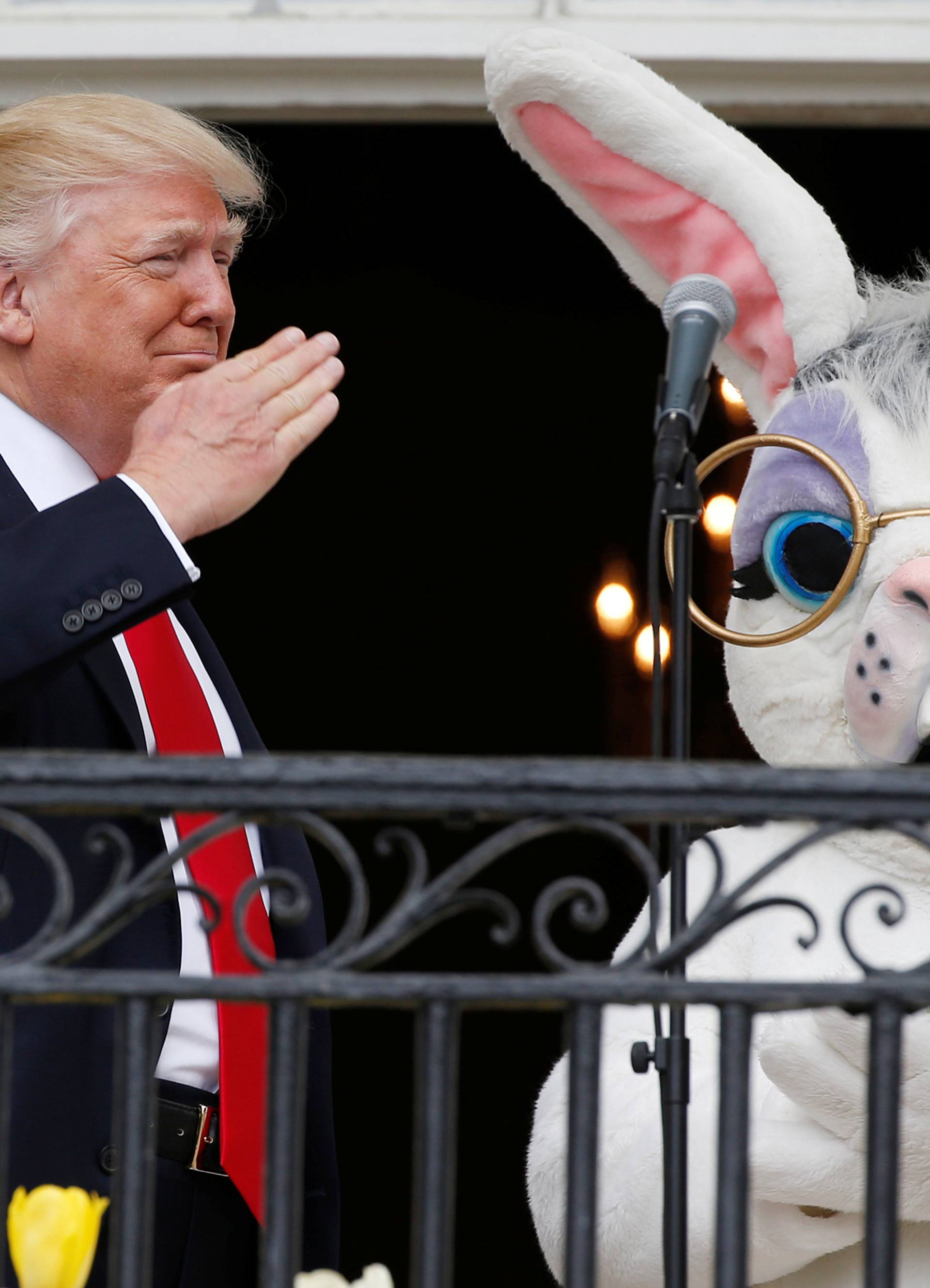 U.S. President Trump salutes a member of the military who had sung the national anthem as he stands with Easter Bunny character at White House Easter Egg Roll in Washington