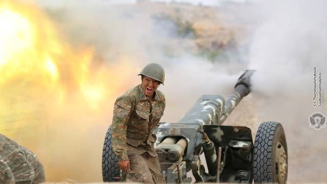 An ethnic Armenian soldier fires an artillery piece during fighting with Azerbaijan's forces in Nagorno-Karabakh