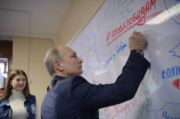 Russian President Vladimir Putin meets with volunteers at his campaign office for the upcoming presidential election in Moscow