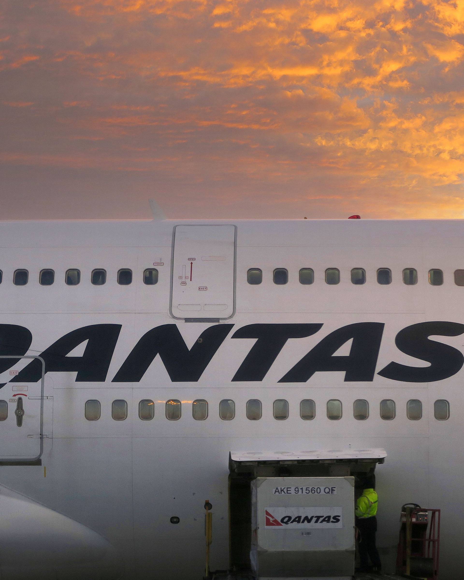 FILE PHOTO -  A worker unloads a Qantas Airways Boeing 747 at Sydney's International airport in Australia