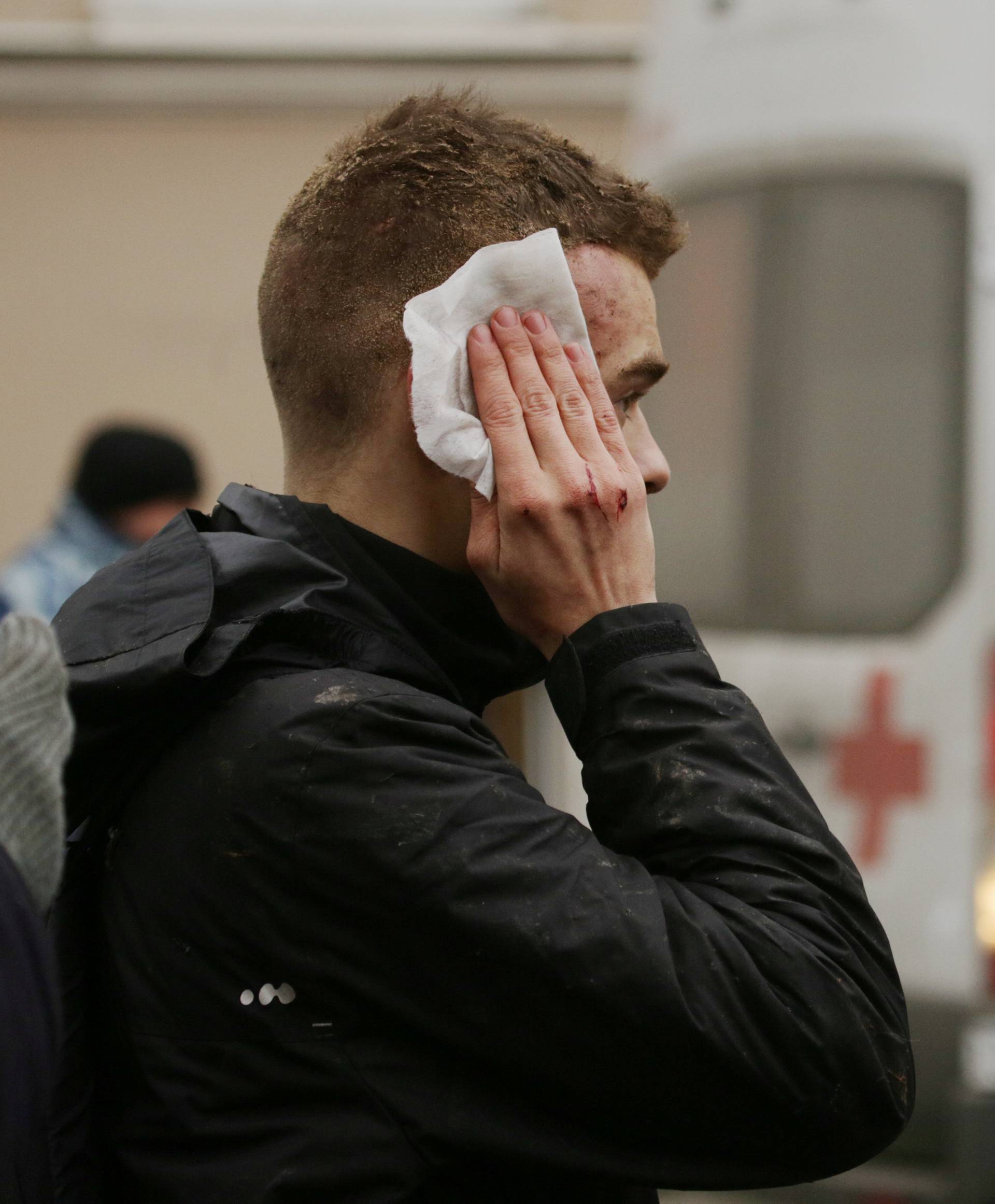 An injured person stands outside Sennaya Ploshchad metro station following explosions in St. Petersburg