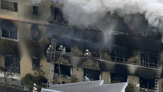 An aerial view shows firefighters battling the fires at the site where a man started a fire after spraying a liquid, at a three-story studio of Kyoto Animation Co. in Kyoto, western Japan, in this photo taken by Kyodo
