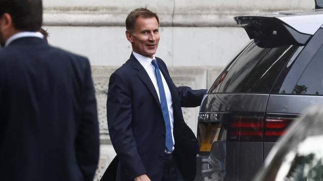 British Chancellor of the Exchequer Jeremy Hunt walks outside Downing Street