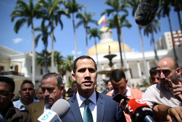 Venezuelan opposition leader Juan Guaido walks as he speaks to journalists before a news conference at the National Assembly in Caracas