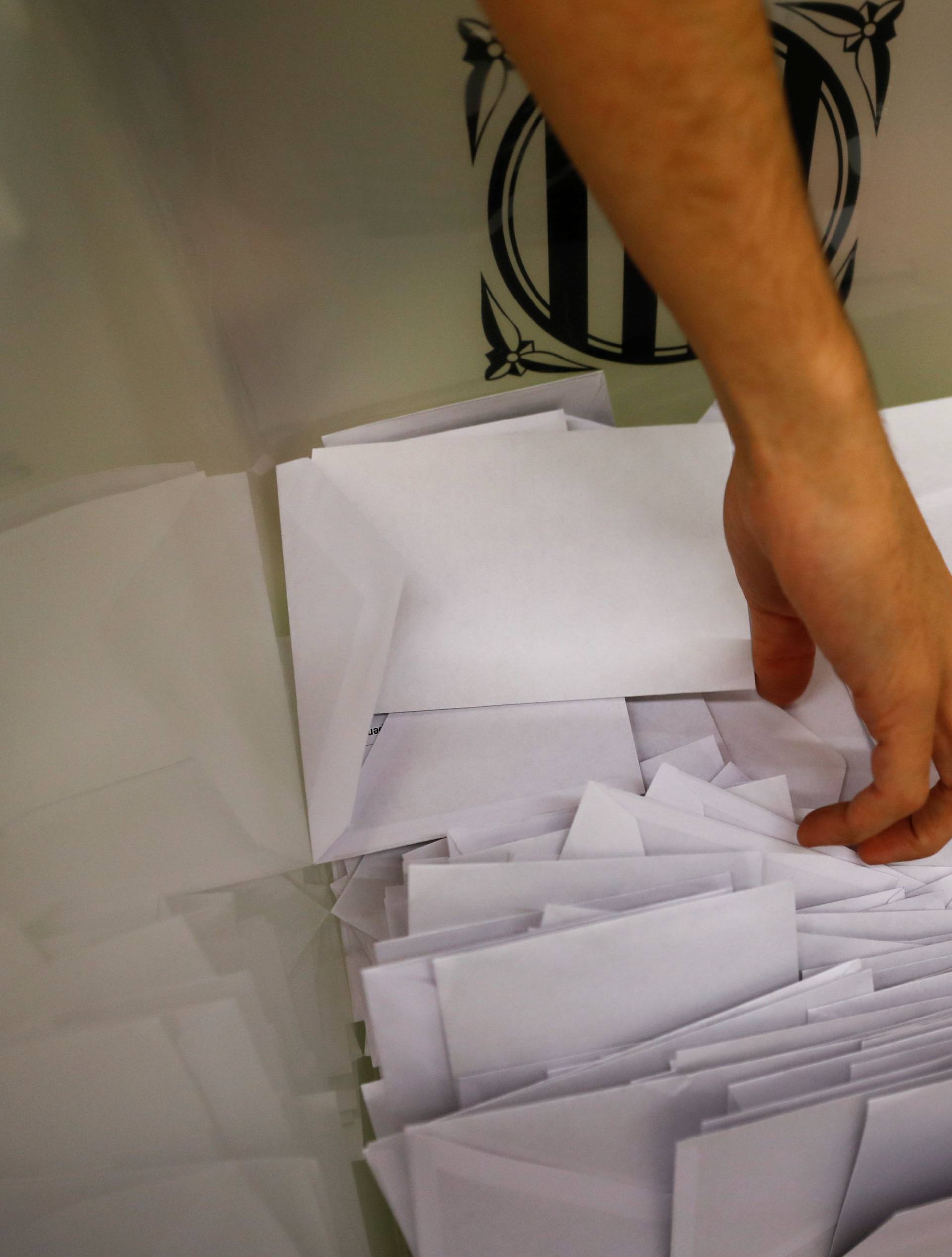 Poll workers count ballots after polls closed at a polling station for the banned independence referendum in Barcelona