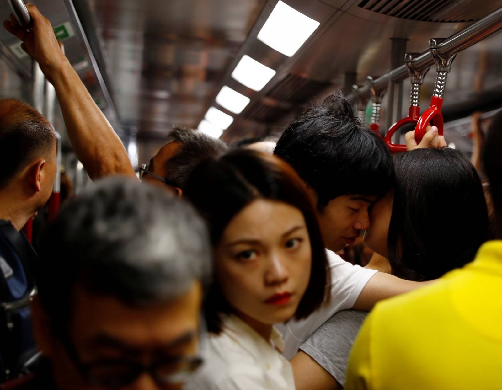 A couple shares a light moment in a Mass Transit Railway subway train in Hong Kong