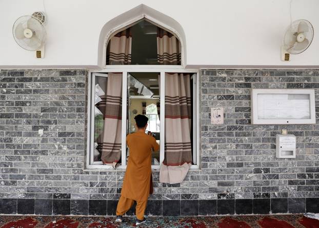 A man films the site of a blast inside a mosque in Kabul, Afghanistan