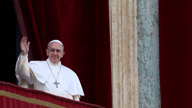 Pope Francis waves after delivering his "Urbi et Orbi" (to the city and the world) message from the balcony overlooking St. Peter's Square at the Vatican