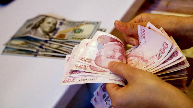 FILE PHOTO: A money changer counts Turkish lira banknotes at a currency exchange office in Ankara
