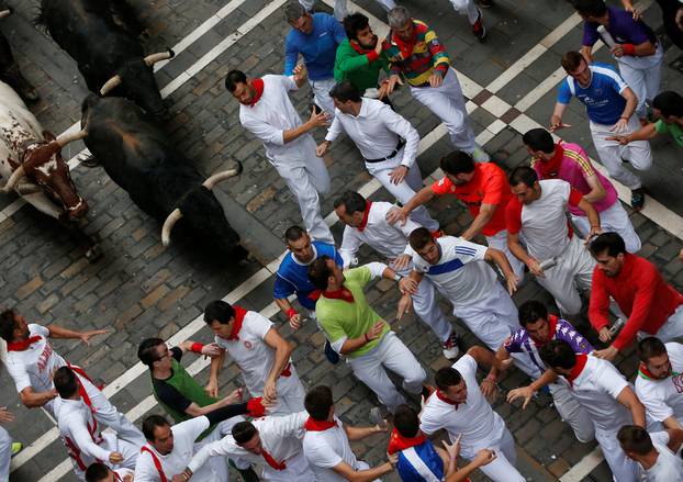 Runners sprint ahead of bulls during the fourth running of the bulls at the San Fermin festival in Pamplona