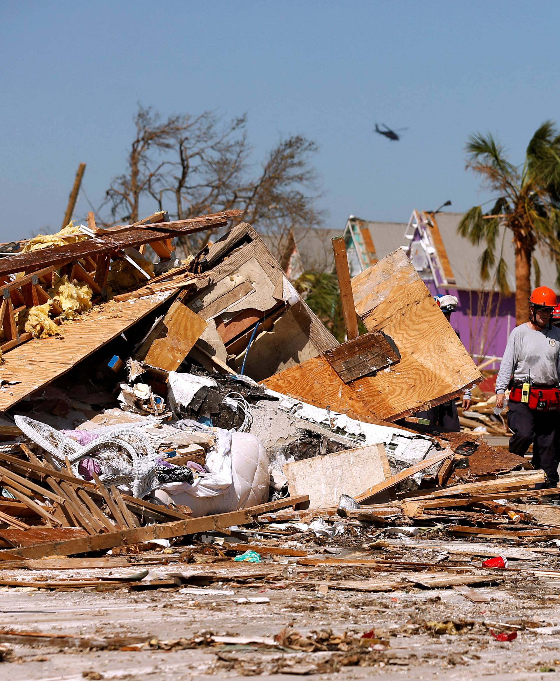 Search and rescue crews walk past debris caused by Hurricane Michael in Mexico Beach