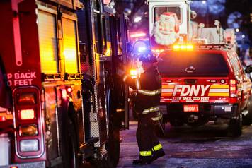 Fire Department of New York (FDNY) personnel work on the scene of an apartment fire in Bronx in New York