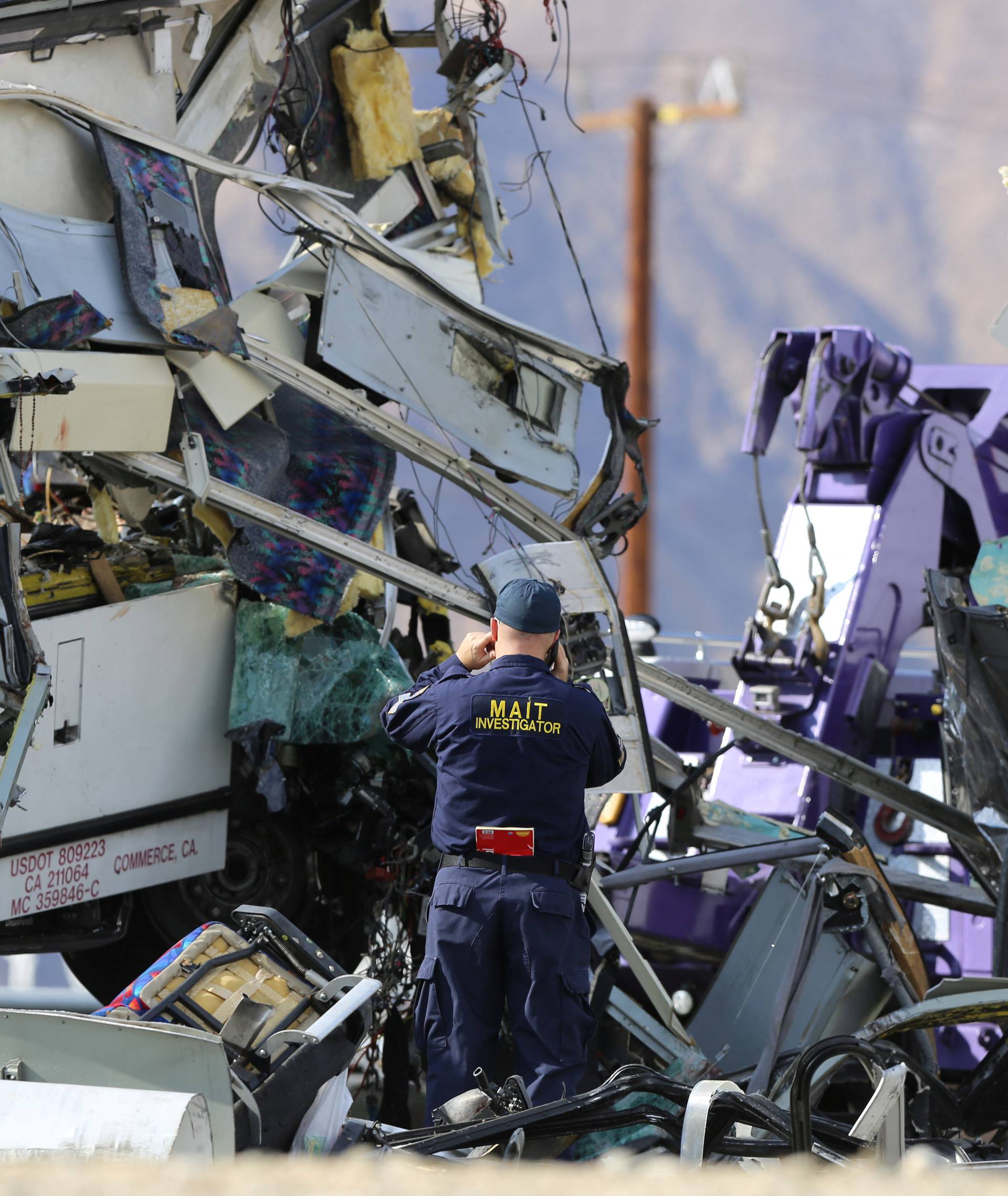 An investigator documents the scene of a mass casualty bus crash on the westbound Interstate 10 freeway near Palm Springs, California