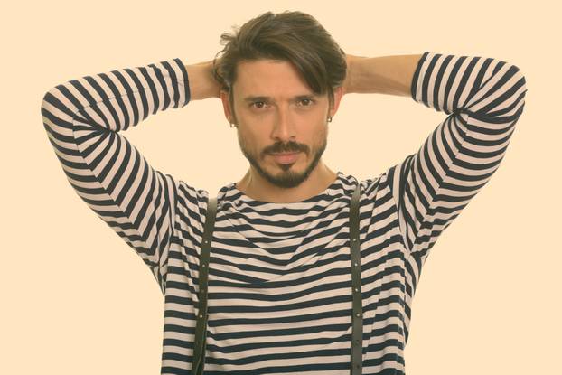 Studio shot of young handsome bearded man