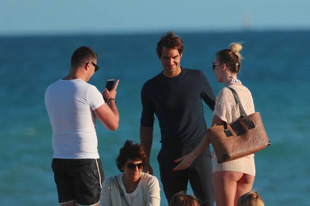 Roger Federer takes selfies with scantily clad woman