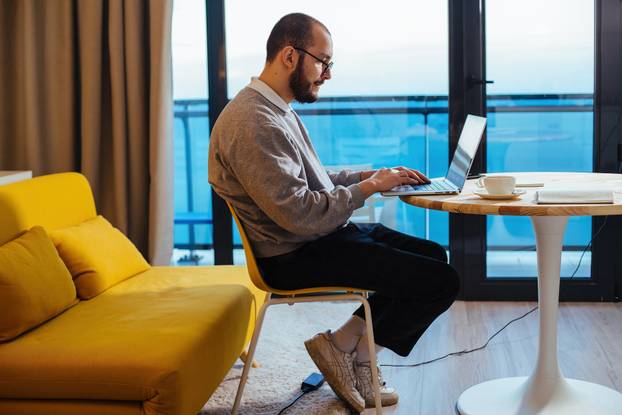 Man working at laptop at home. Freelance or distance job concept