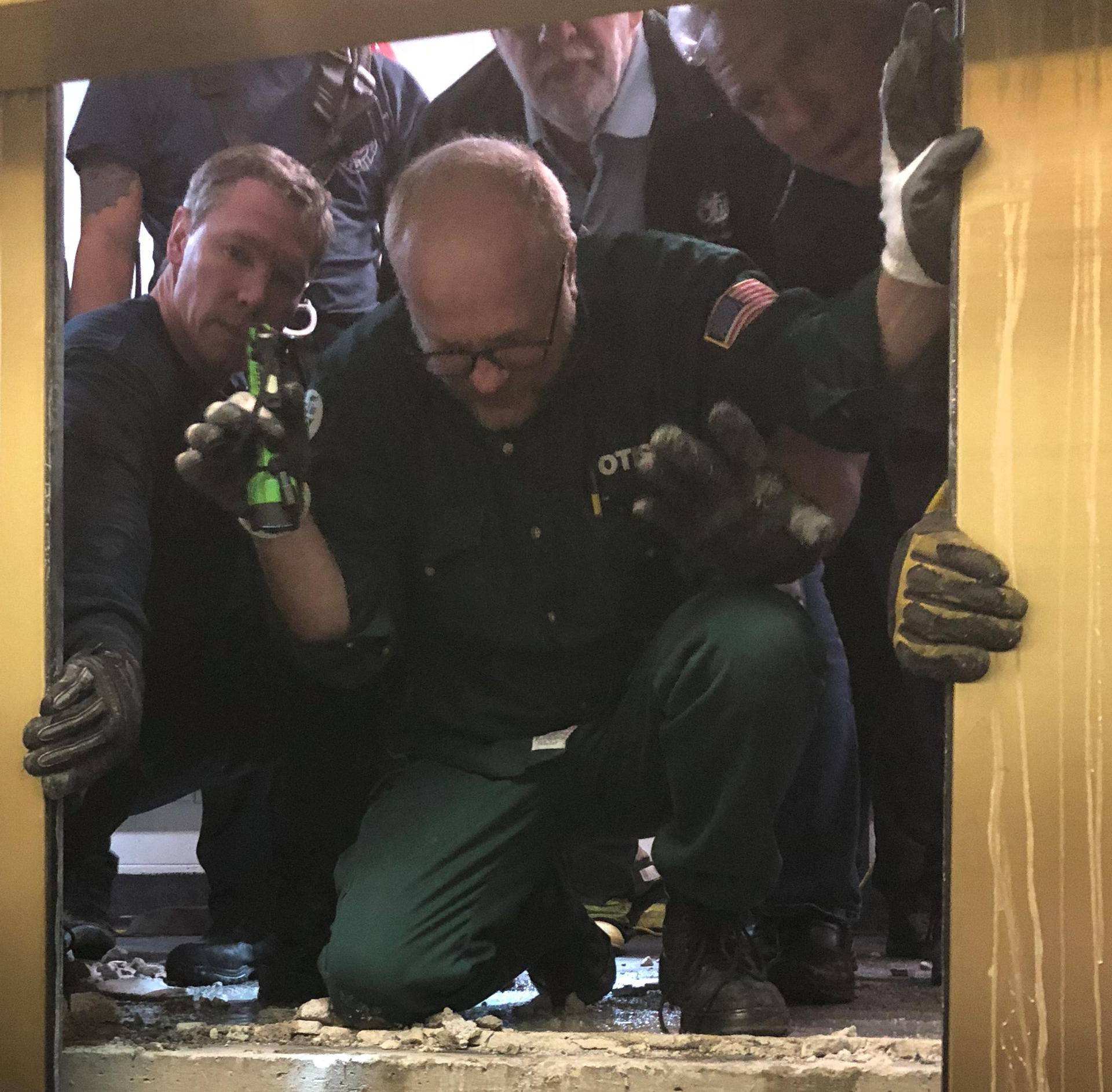 Rescue crew open the door to pull out six people trapped in an elevator of the 875 North Michigan Avenue building in Chicago